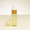 4 ml flesje etherische lelietje-van-dalen-olie naast een lelietje-van-dalen bloem