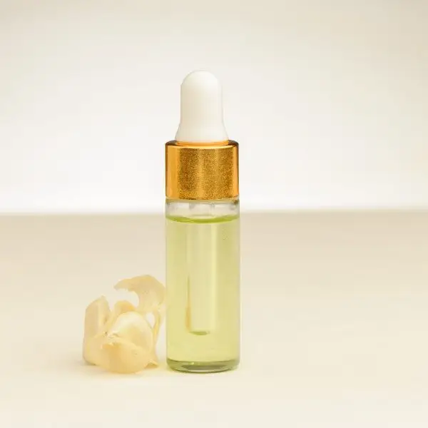 4 ml flesje etherische lelietje-van-dalen-olie naast een lelietje-van-dalen bloem