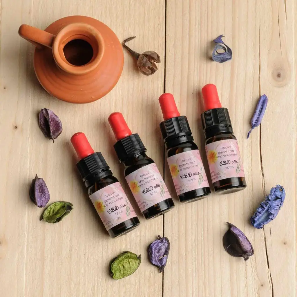Vier CBD olie flesjes in verschillende concentraties bij gebruiksaanwijzing.